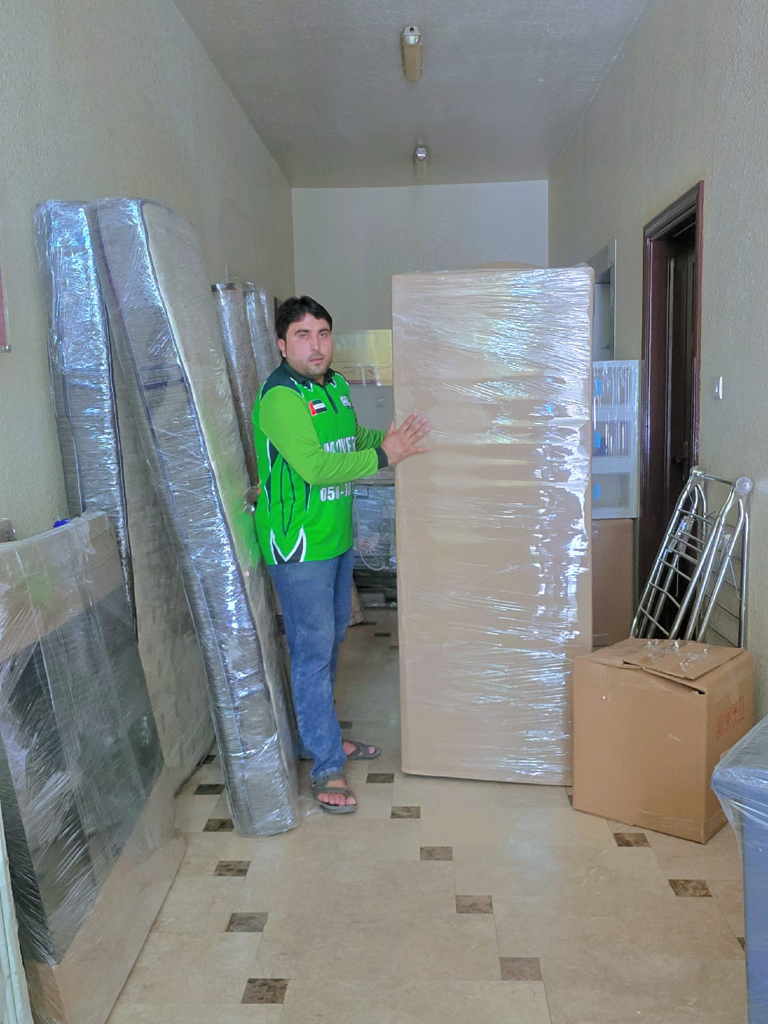 Furniture movers in Al Ain loading wrapped furniture into a truck